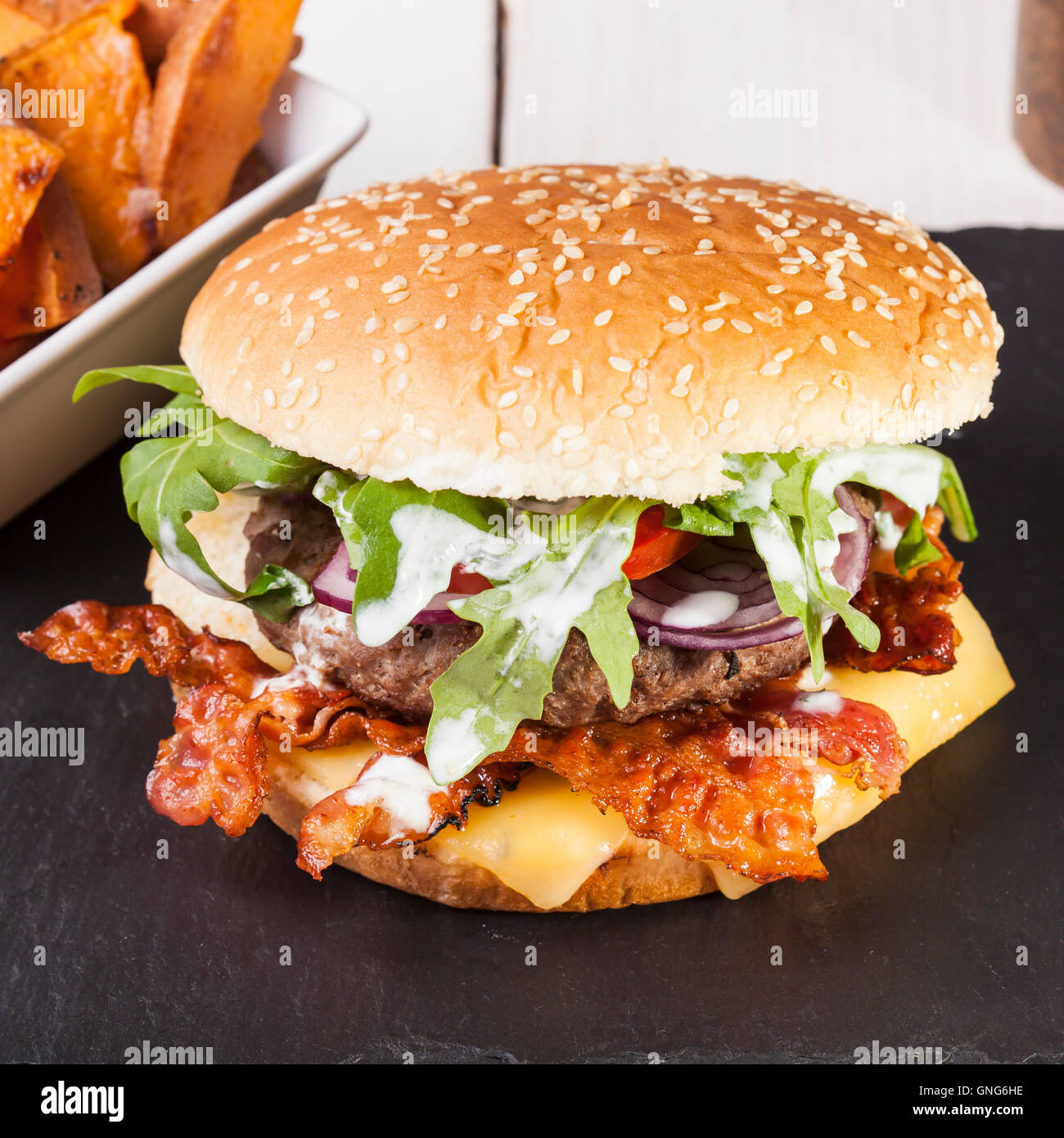 Gourmet home realizzati bacon cheeseburger su rustiche sfondi in legno Foto Stock