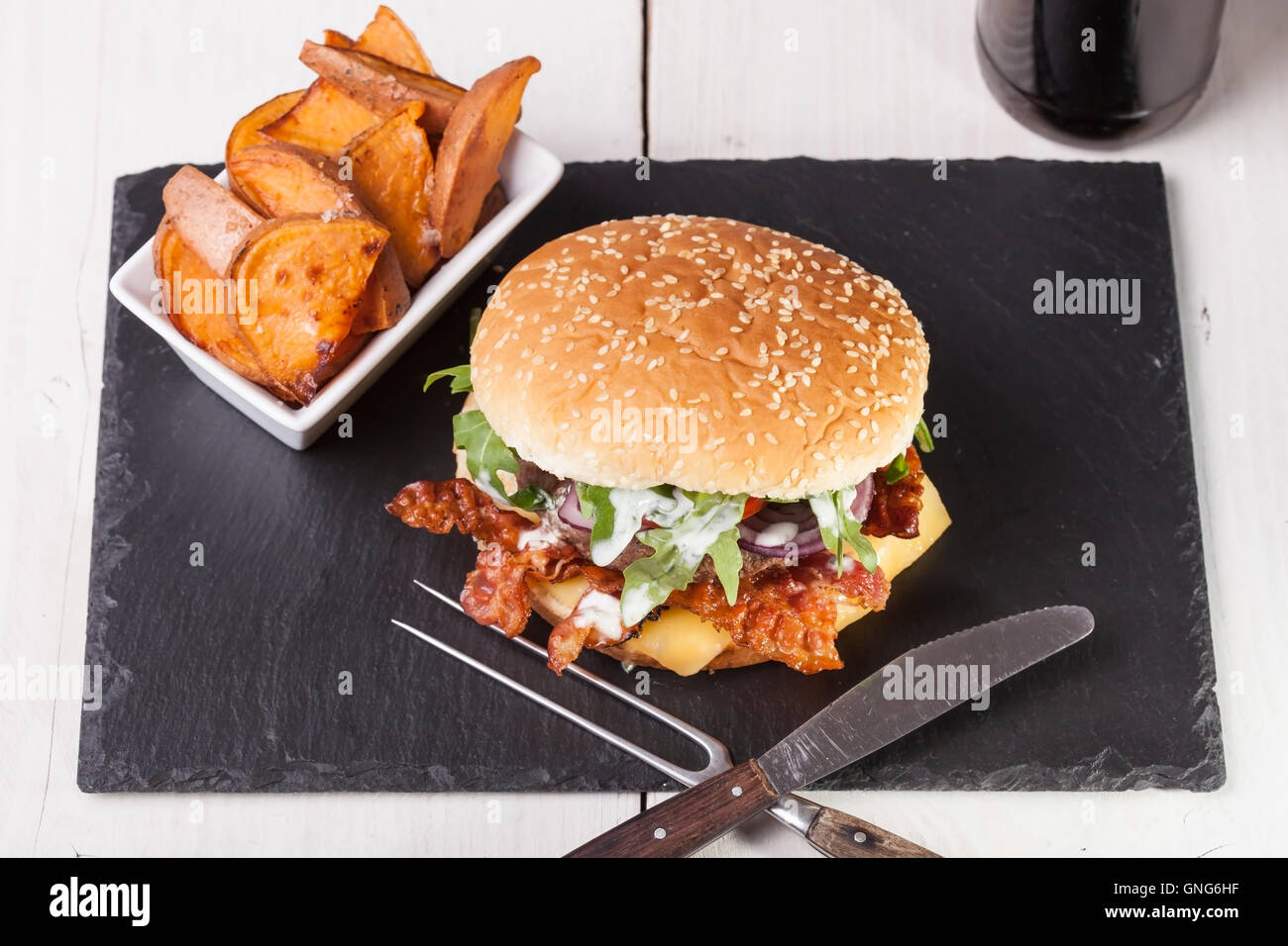 Gourmet home realizzati bacon cheeseburger su rustiche sfondi in legno Foto Stock