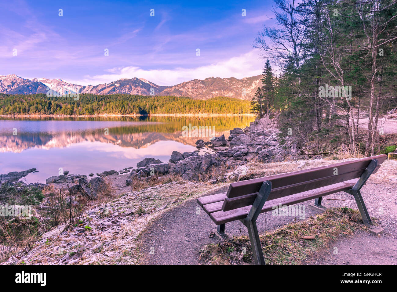 Panca sulla riva di un lago alpino Foto Stock