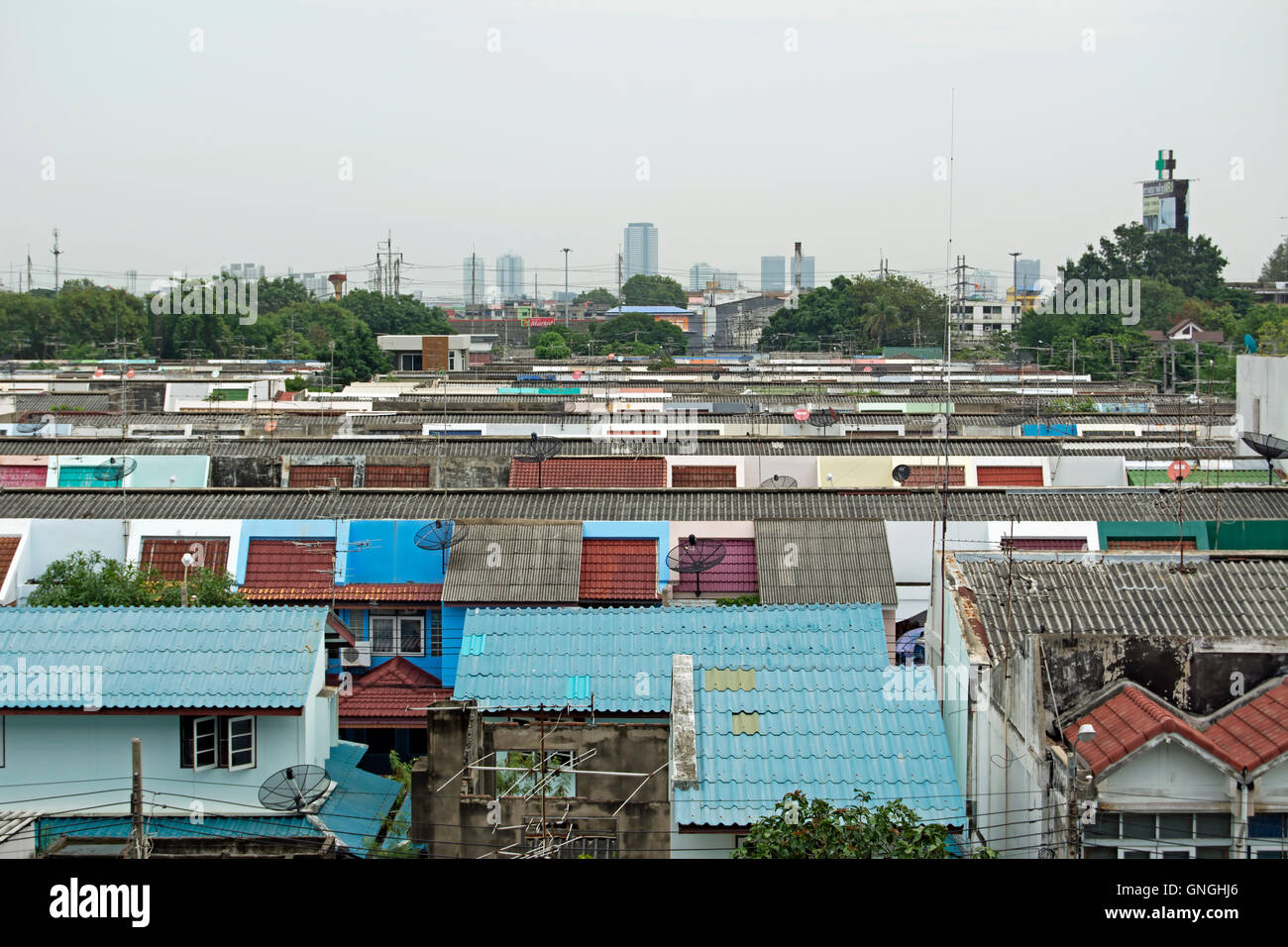 Vista sui tetti della classe operaia area di Samut Prakan verso gli edifici ad alta del centro di Bangkok, Thailandia Foto Stock