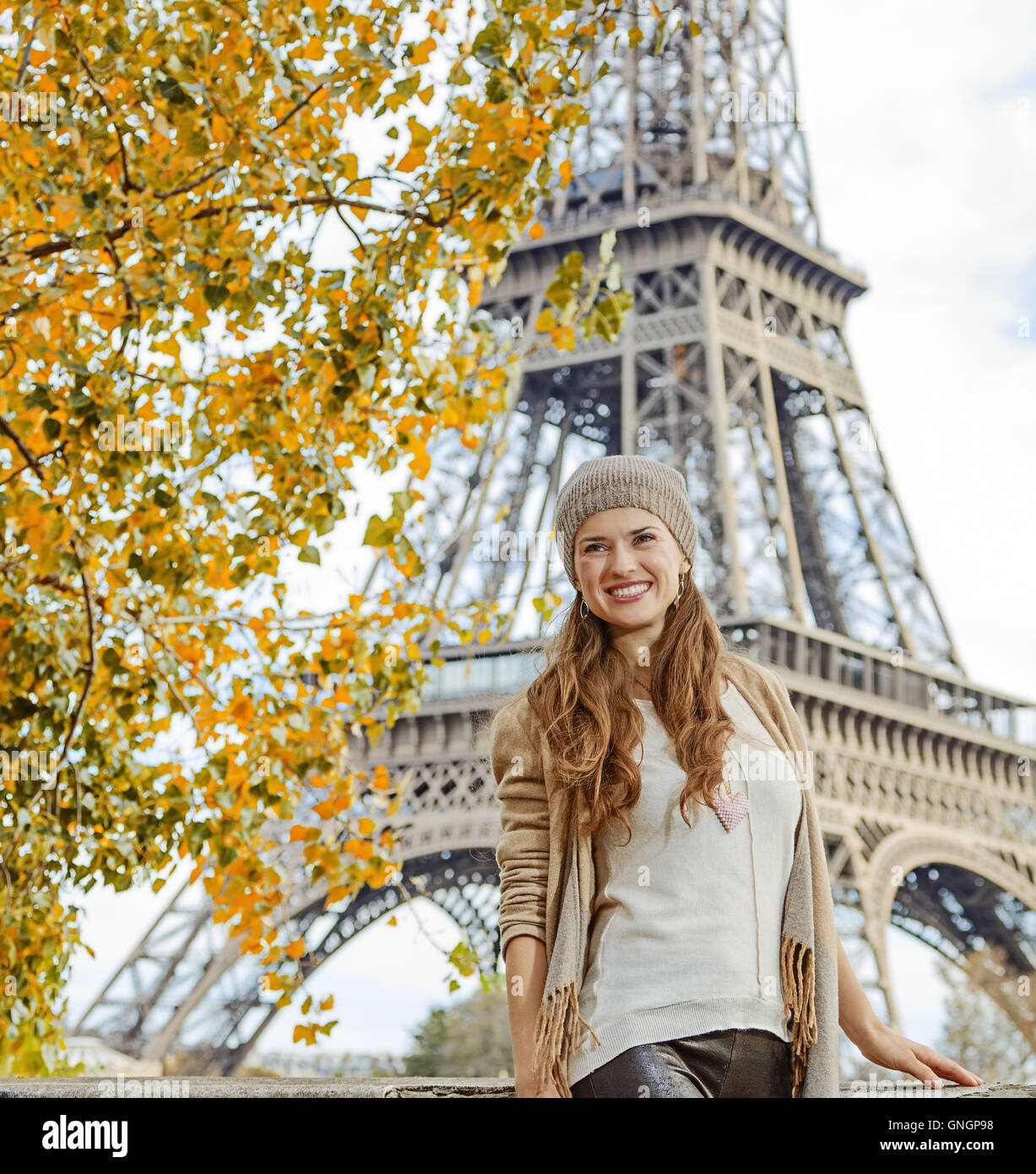 Fughe d'autunno a Parigi. sorridente giovane donna elegante sul terrapieno vicino alla Torre Eiffel a Parigi in Francia ad esplorare le attrazioni Foto Stock