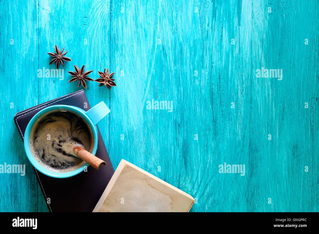 Rustico Tazza da caffè sul vecchio libro e un blu tavolo in legno. Foto Stock