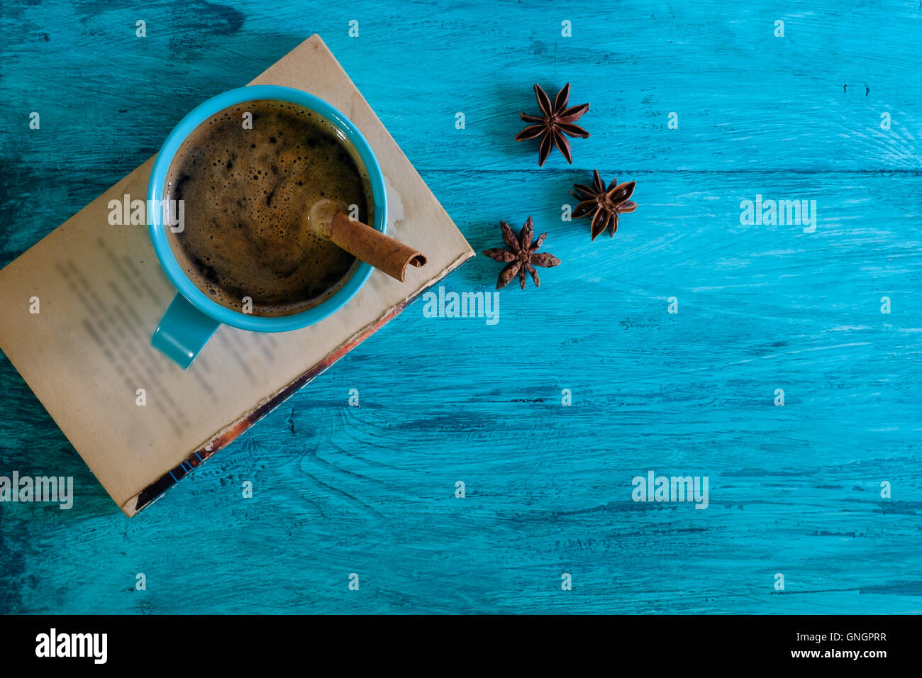 Rustico Tazza da caffè sul vecchio libro e un blu tavolo in legno. Foto Stock