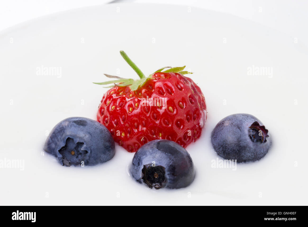 Close-up di yogurt bianco con mirtilli e fragole e lamponi Foto Stock