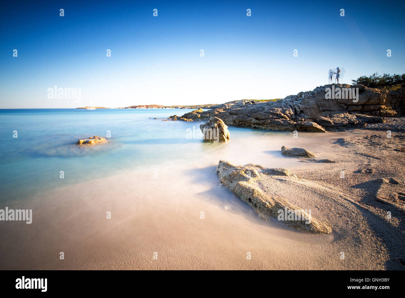 Silhouette di due persone in piedi su rocce alla spiaggia vicino Calvi, Corsica, Francia Foto Stock