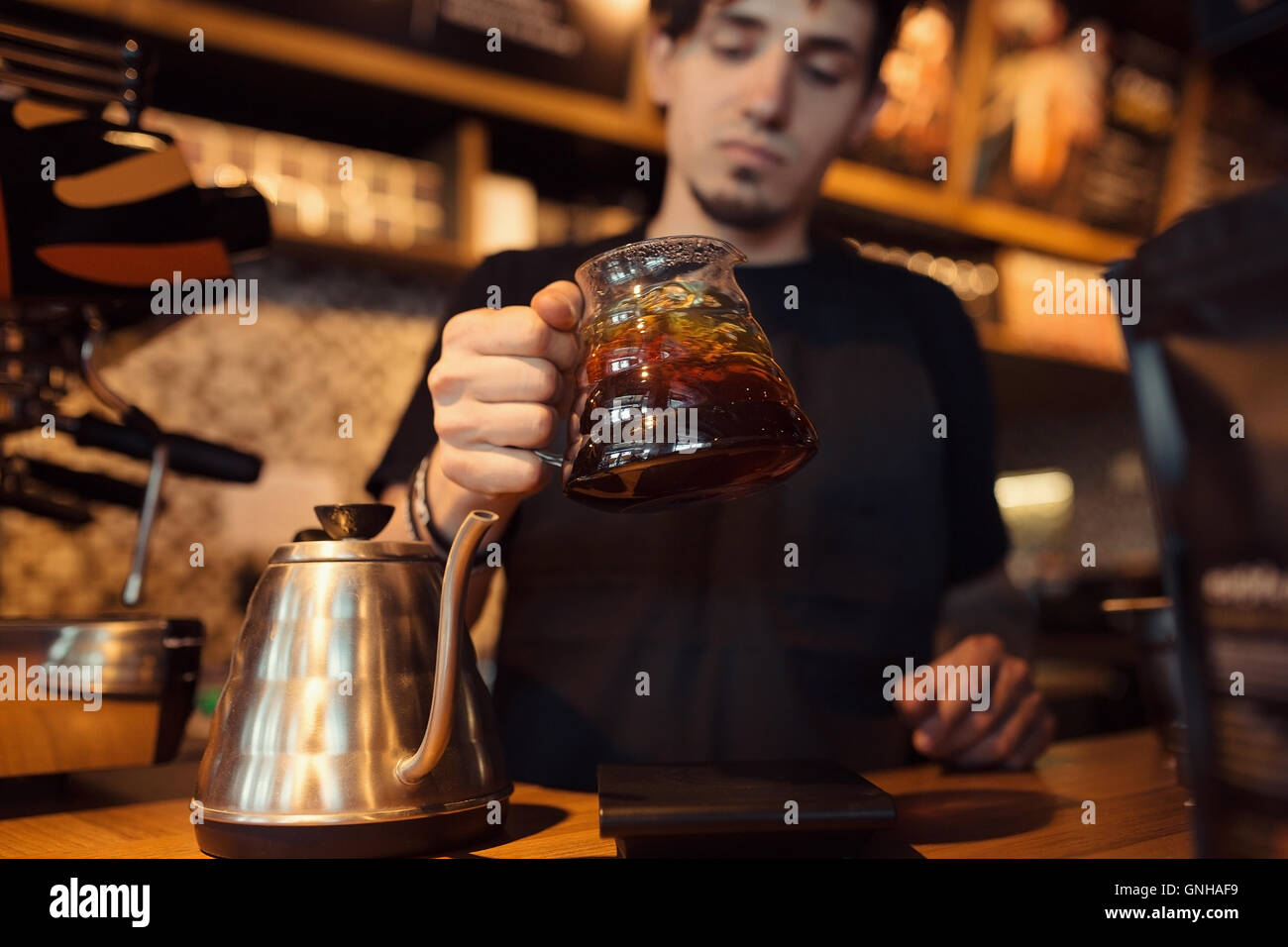 Barista a lavorare in un negozio di caffè Foto Stock