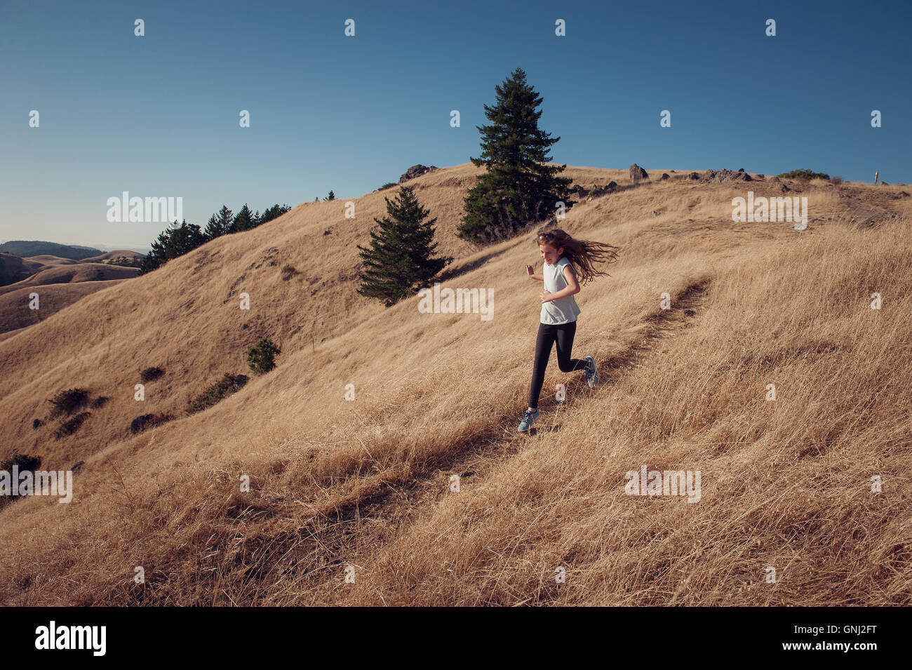 Ragazza che corre giù la montagna, California, Stati Uniti Foto Stock