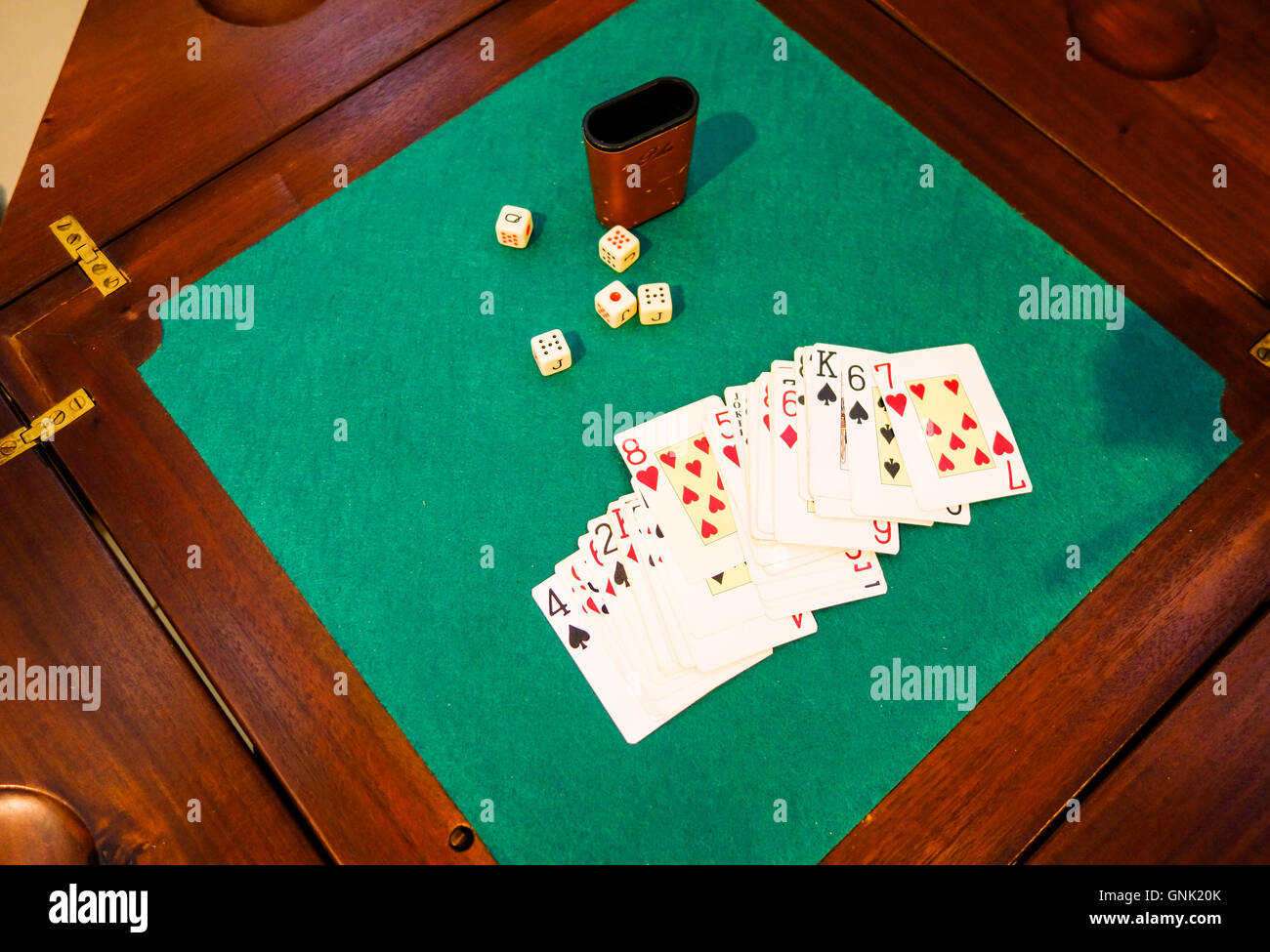 Vintage tavolo da gioco con le carte da gioco e dadi, sfondo verde. Foto Stock