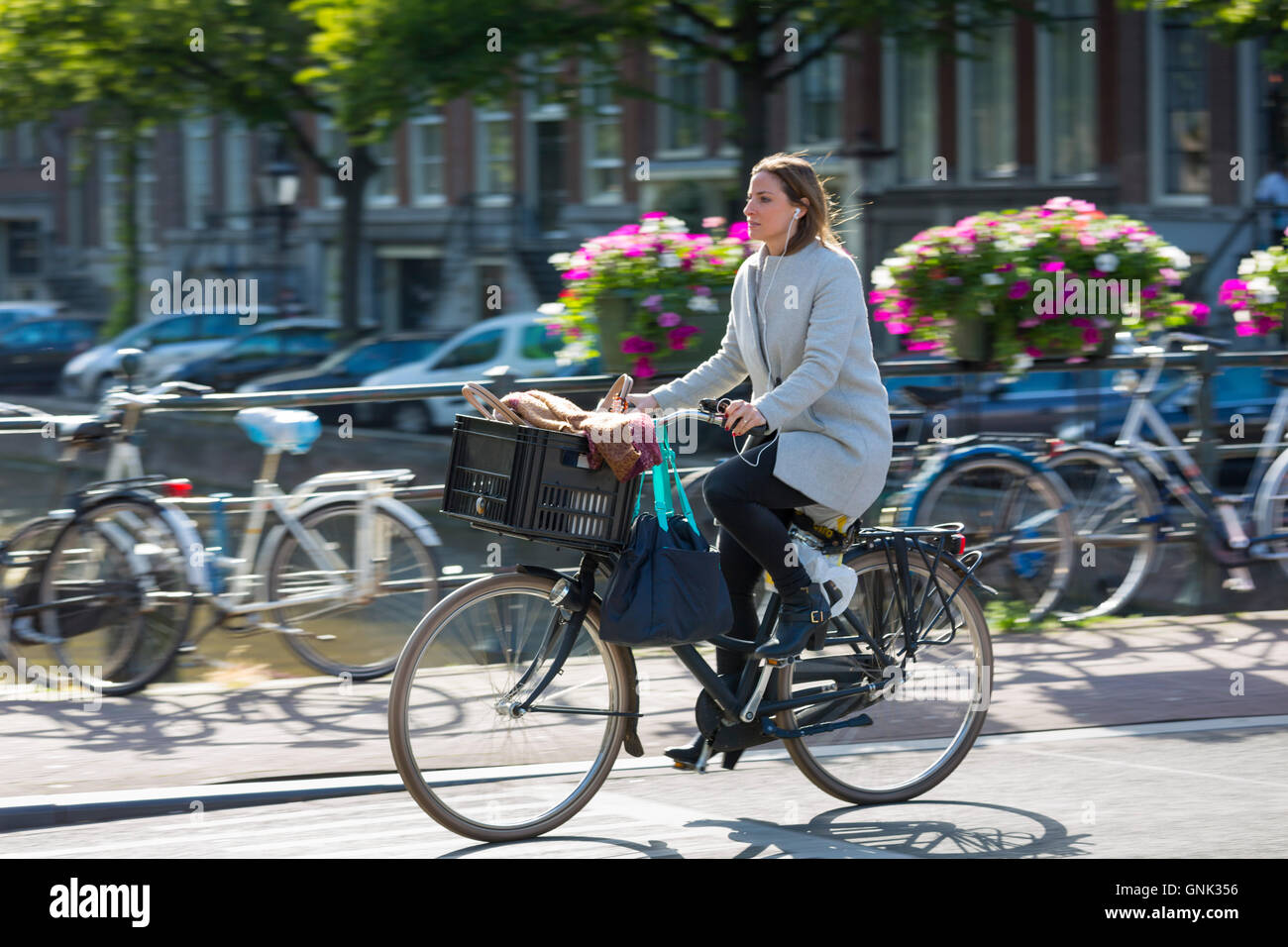 Giovane donna di indossare tacchi alti scarpe e le cuffie ciclismo fuori la  sera per tutta ponte in Amsterdam, Olanda Foto stock - Alamy