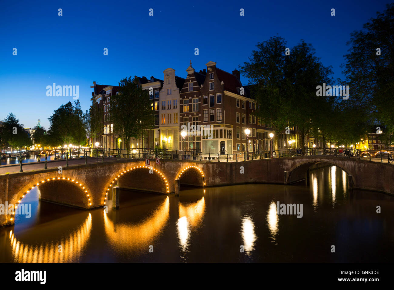 Ponti illuminati a Kaisersgracht e Leidsegracht, canal ring area, quartiere Jordaan, Amsterdam Foto Stock