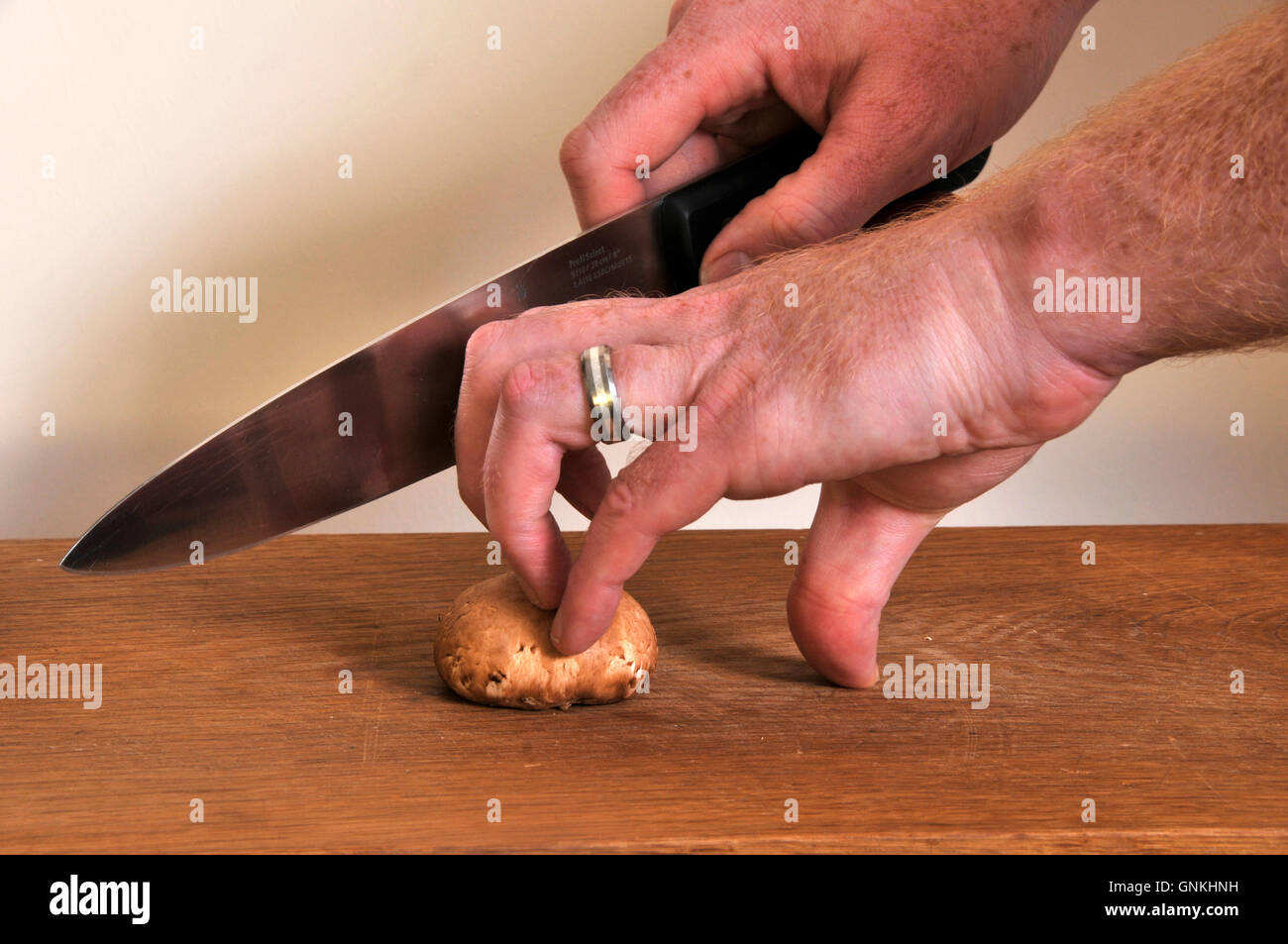 La trinciatura tenendo un fungo Foto Stock