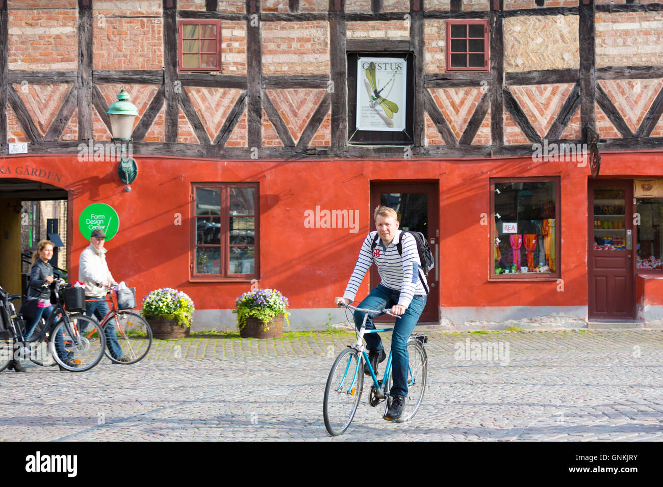 Giovane uomo ciclismo in piazza della città vecchia di Malmo, Svezia Foto Stock