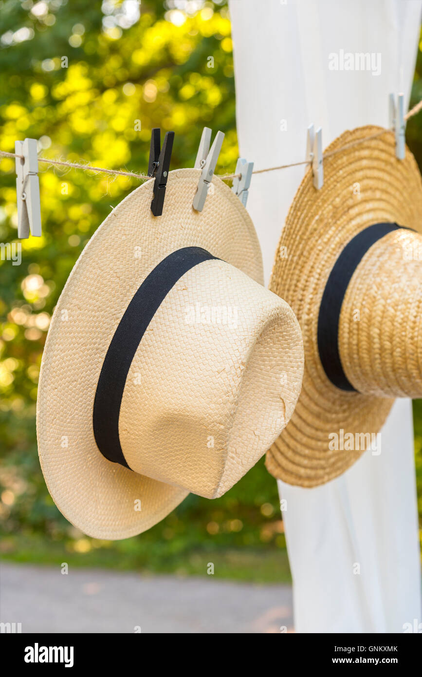 Immagine di cappelli di paglia appesi su una linea di abbigliamento outdoor. Foto Stock