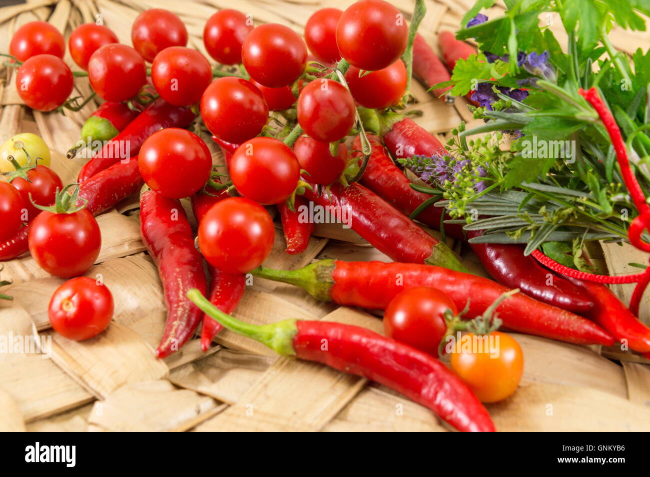 Peperoni rossi e freschi pomodori ciliegia su sfondo di legno Foto Stock