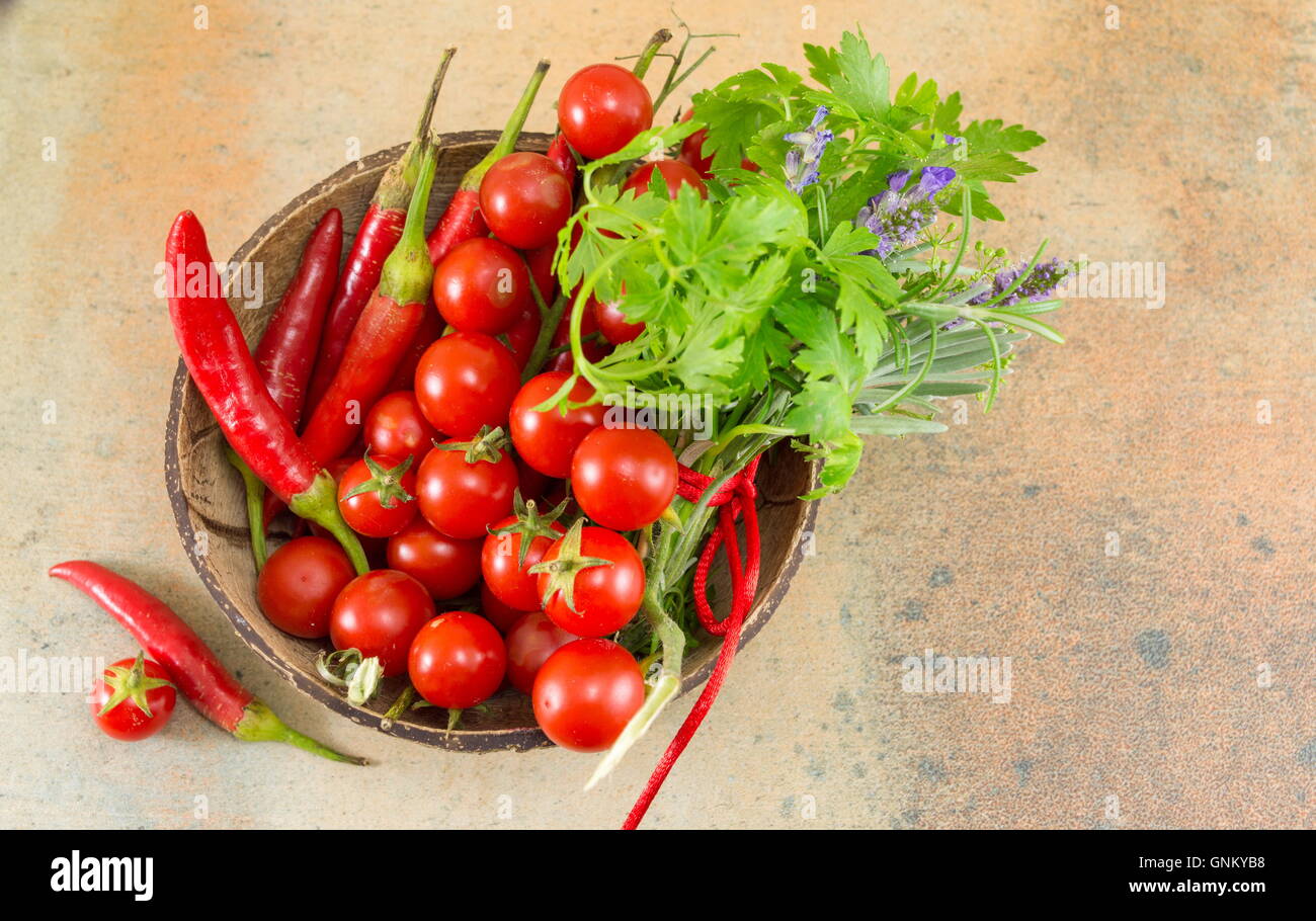 Peperoni rossi e freschi pomodori ciliegia su sfondo di legno Foto Stock