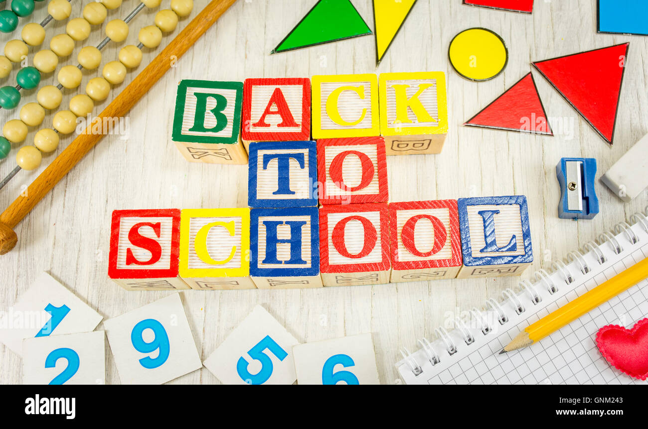 Si torna a scuola scritto con lettere in legno e strumenti di apprendimento Foto Stock