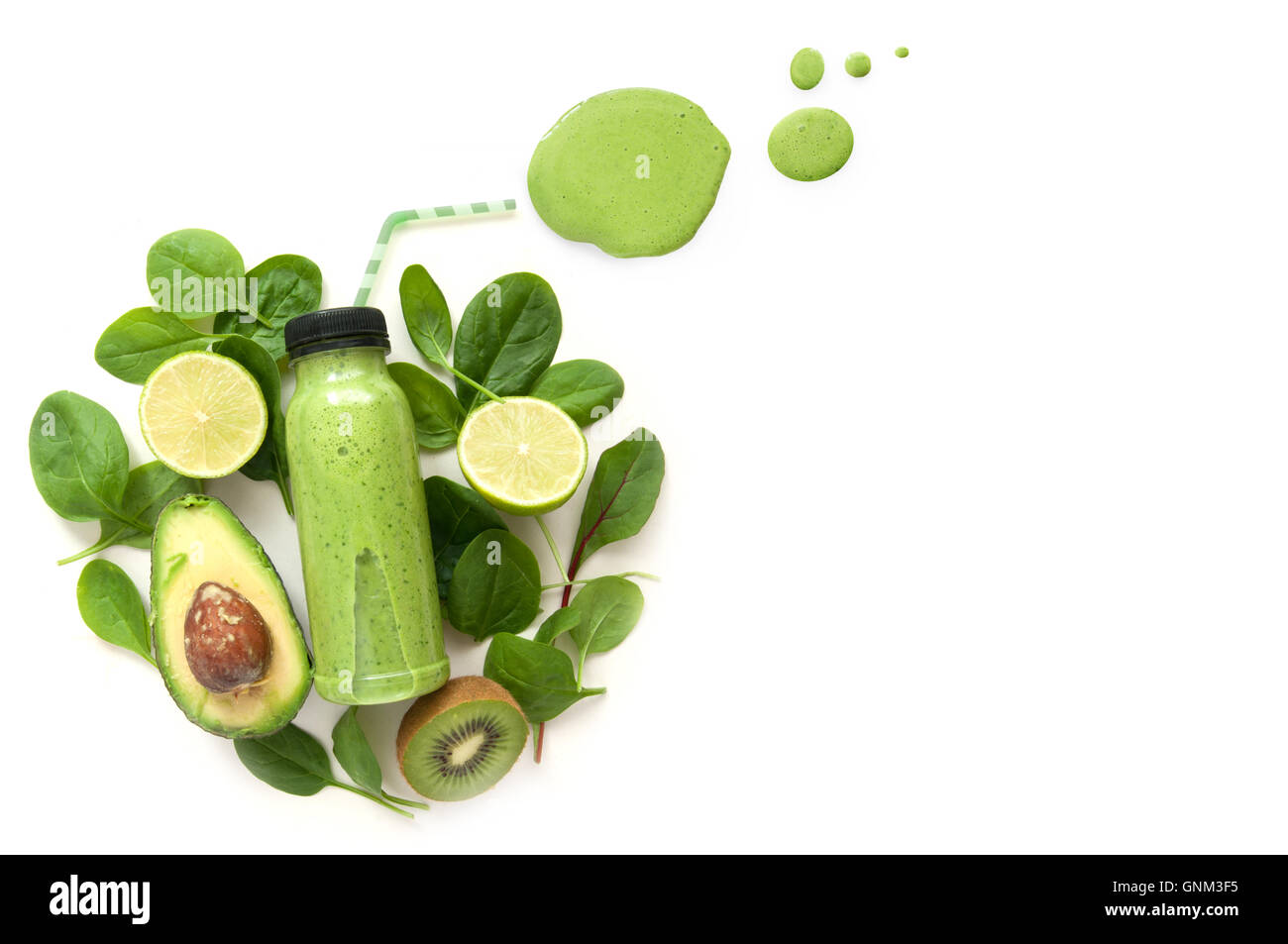 Imbottigliato frullato verde circondato da verde alimenti compresi gli spinaci e kiwi Foto Stock