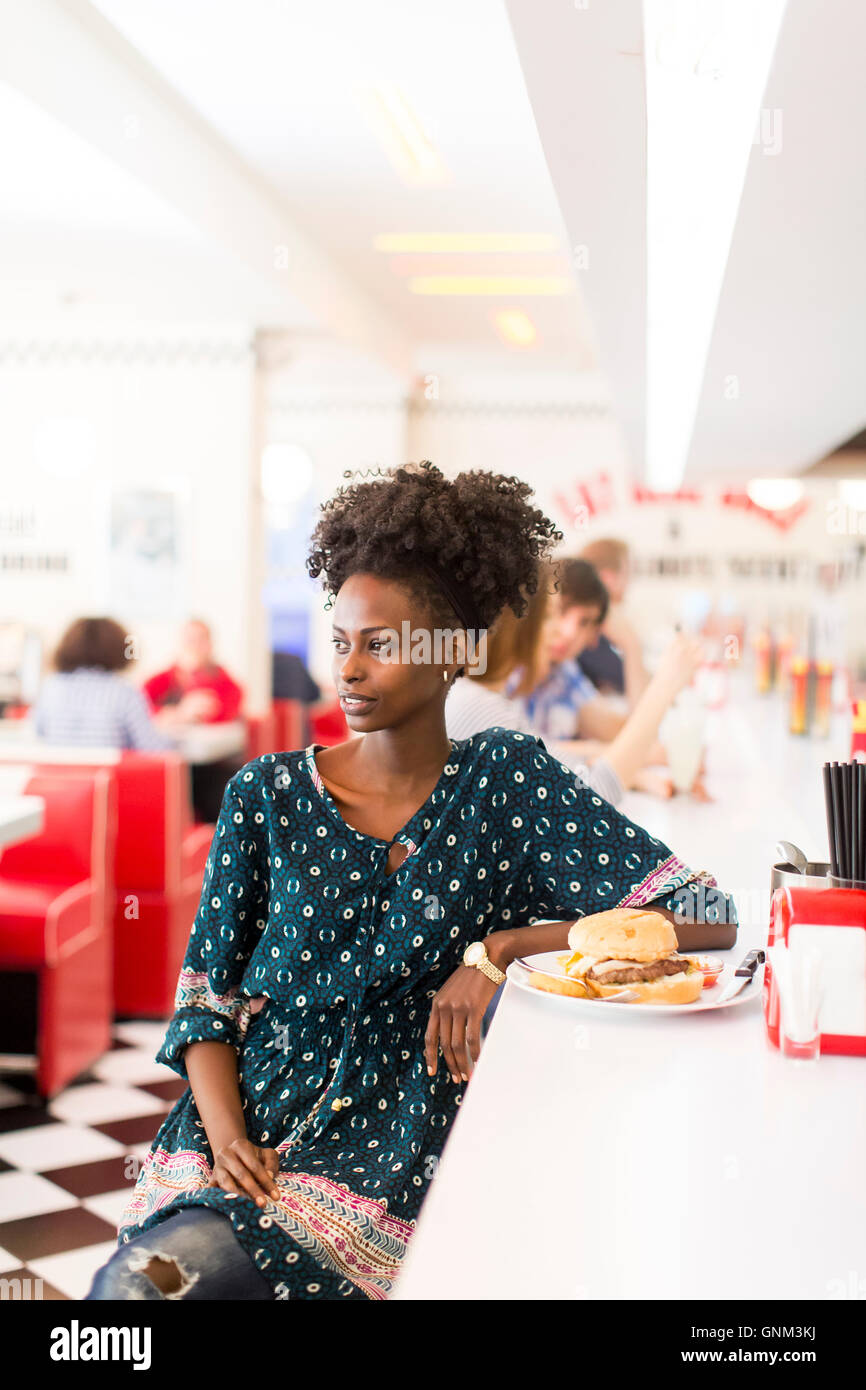 Giovane africano donna americana nel diner Foto Stock