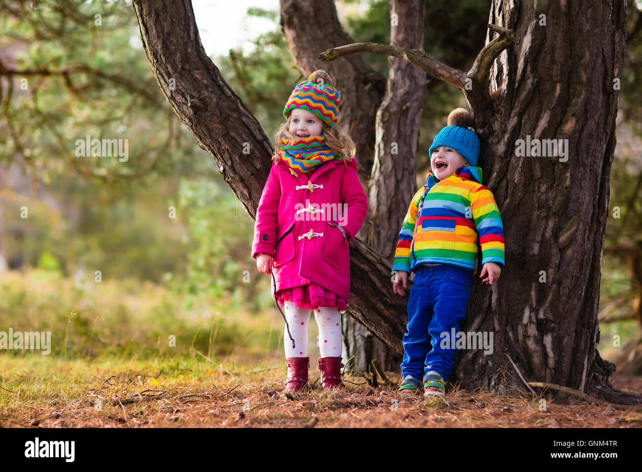 Dei bambini felici giocando in autunno magnifico parco sulla soleggiata freddo giorno di caduta. Kids in giacche calde giocare con foglie d'oro. Foto Stock