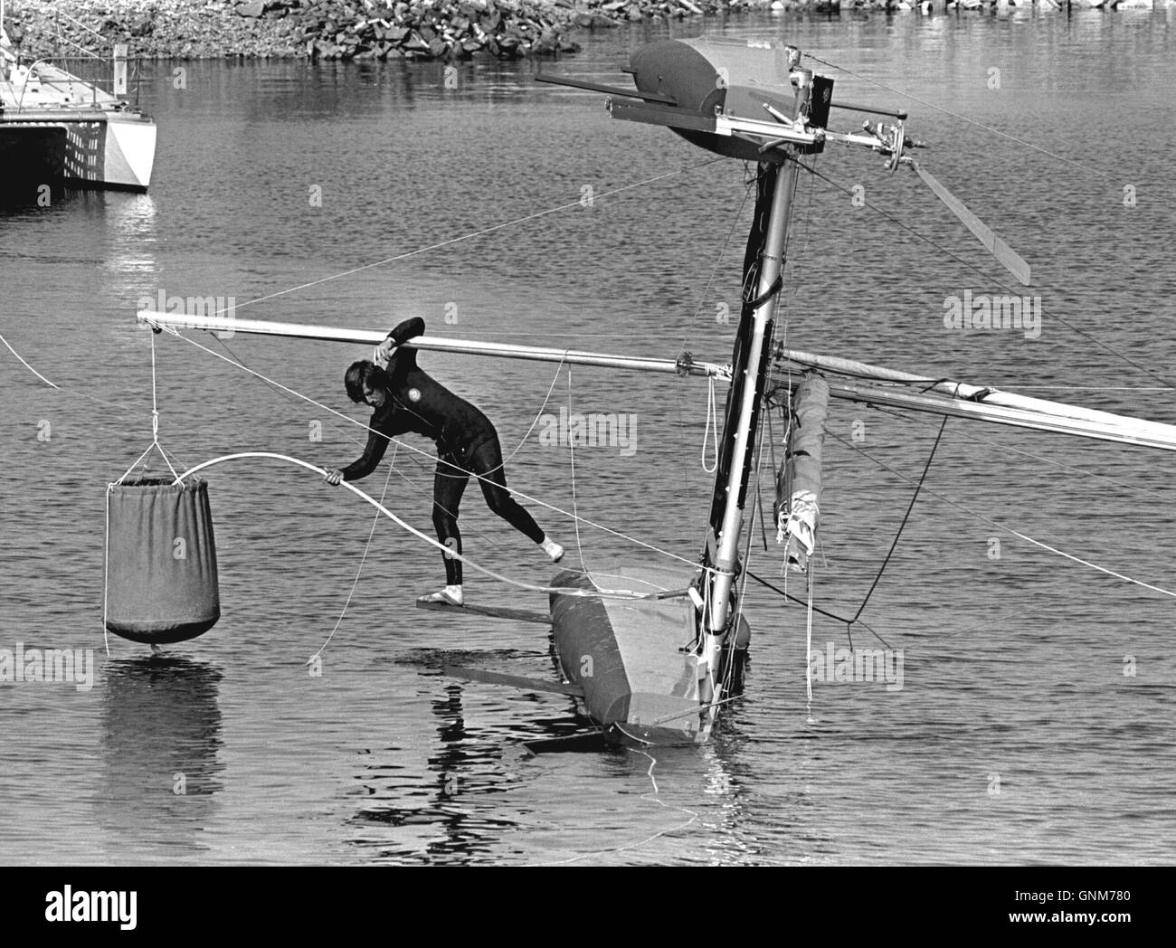 AJAX NEWS FOTO. 1976. PLYMOUTH in Inghilterra. - OSTAR RACE - Auto sistema di raddrizzamento! - La voce italiana Ambrogio Fogar, skipper di spirito di sorpresa, dimostra il suo catamarano di autoalimentazione del sistema di raddrizzamento PER GLI ORGANIZZATORI DI GARA IN MILBAY DOCKS prima dell inizio della gara. Foto:JONATHAN EASTLAND/AJAX REF:BW2760506 1 Foto Stock