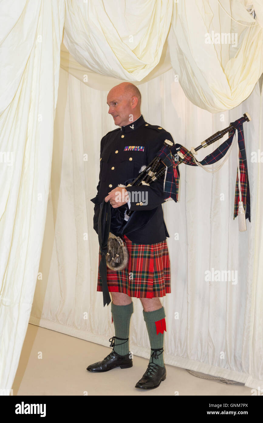 Scottish piper ad ingresso a wedding marquee, Preston Bissett, Buckinghamshire, Inghilterra, Regno Unito Foto Stock