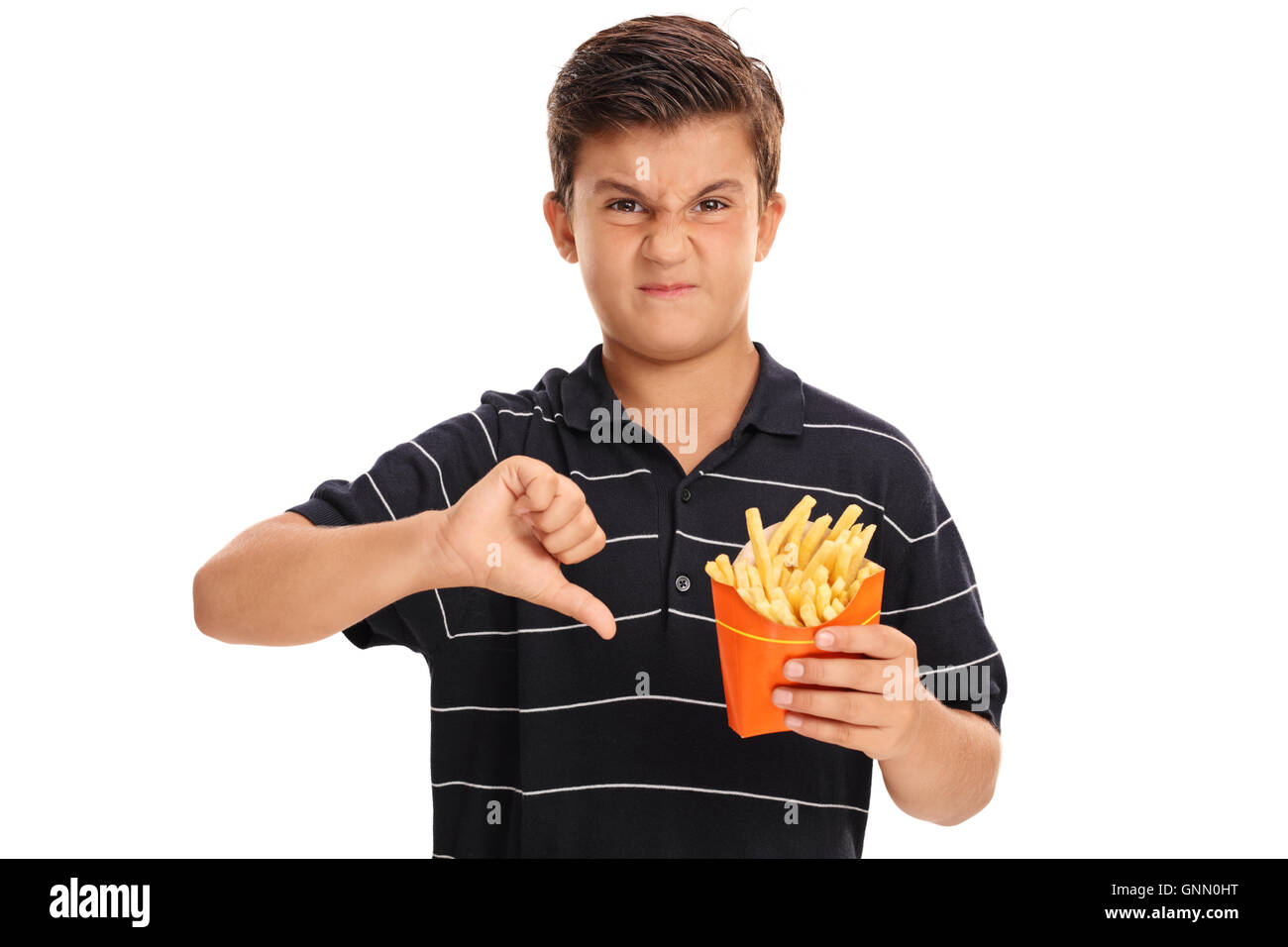 Deluso kid tenendo un sacchetto di patatine fritte e facendo un pollice in basso segno isolato su sfondo bianco Foto Stock