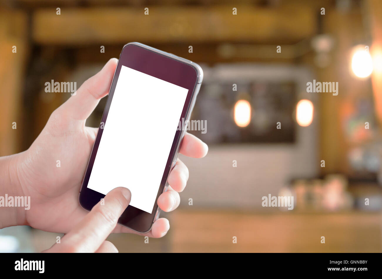 Smart phone nella donna la mano con coffee shop sfocato sfondo astratto Foto Stock