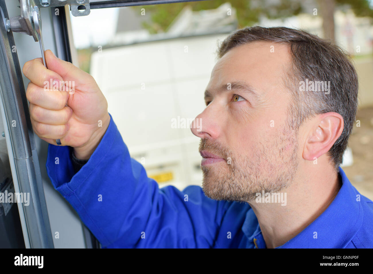 L'uomo l'installazione di una porta di garage Foto Stock