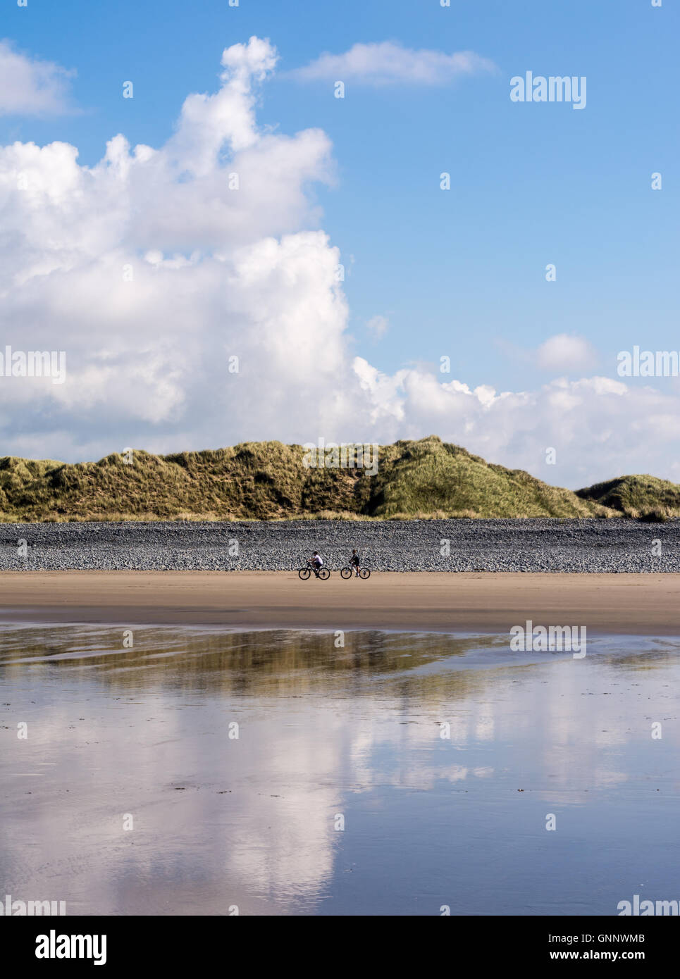 Due persone ciclismo su Ynyslas Beach, vicino a Aberystwyth in Ceredigion, Wales UK Foto Stock