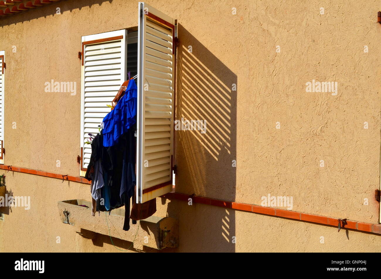 Panni stesi su un otturatore di un francese del sud edificio durante il sunshine Foto Stock