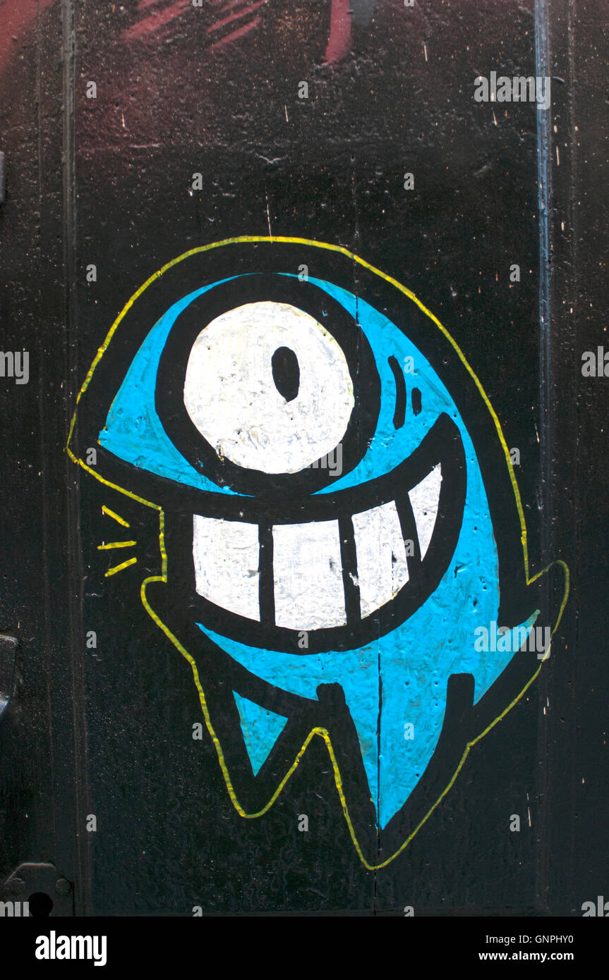 Divertente e divertente personaggio dipinta sulla porta sul retro strade del Barri Gotic area, Barcellona. Foto Stock