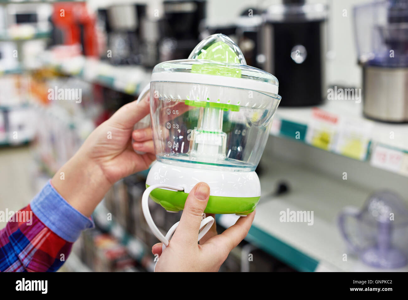 Spremiagrumi elettrico nelle mani del compratore presso il negozio Foto Stock
