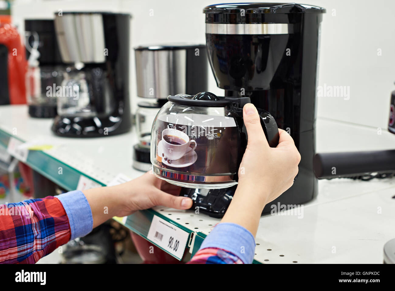 Acquirente sceglie la macchina per il caffè in negozio Foto Stock