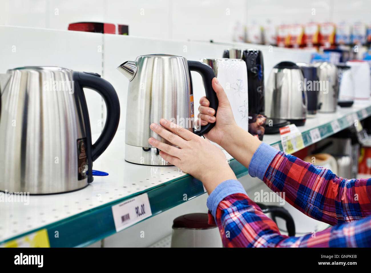 Donna casalinga shopping per il bollitore elettrico Foto Stock