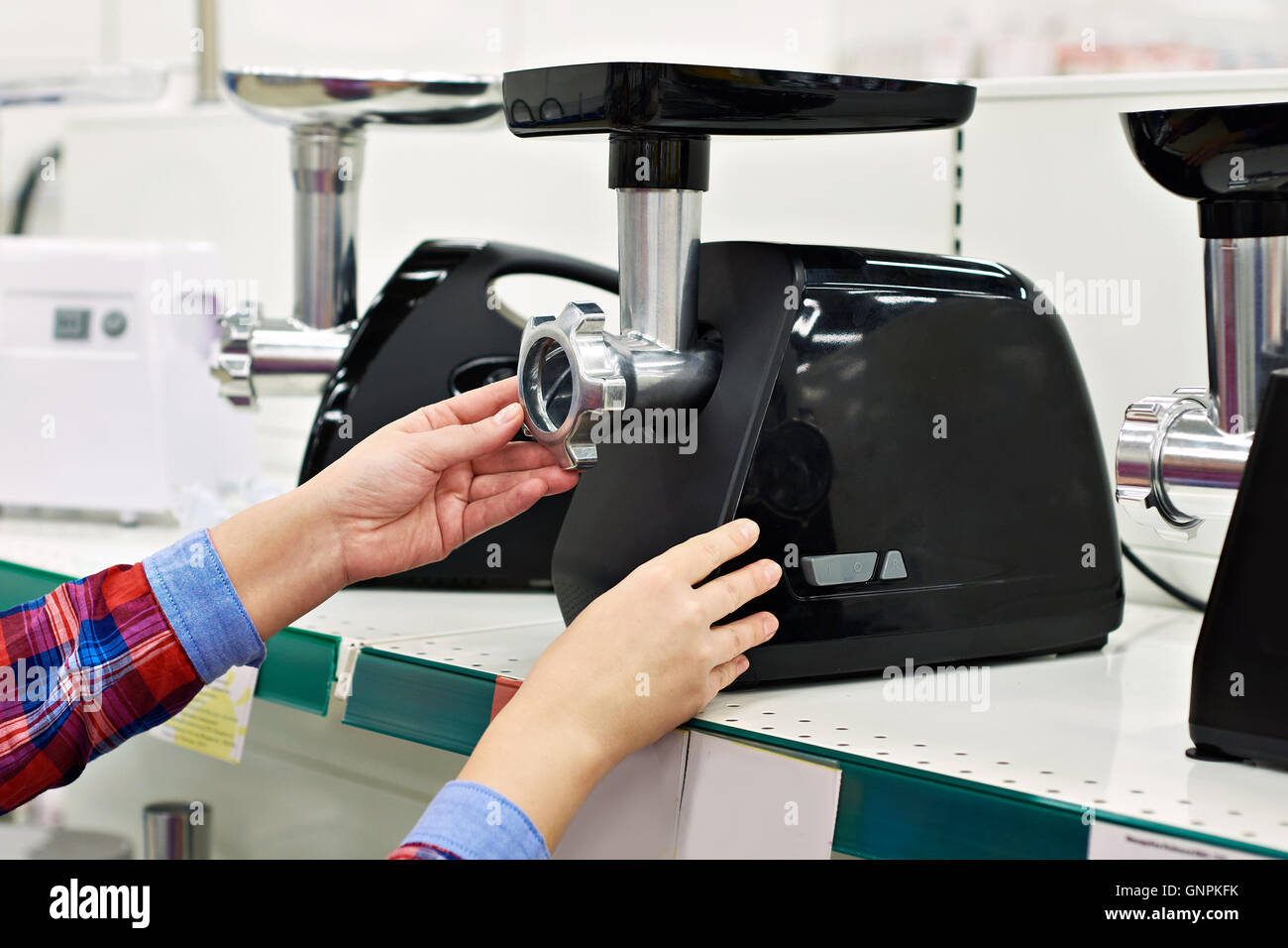 Donna casalinga sceglie l'Electric tritacarne in negozio Foto Stock