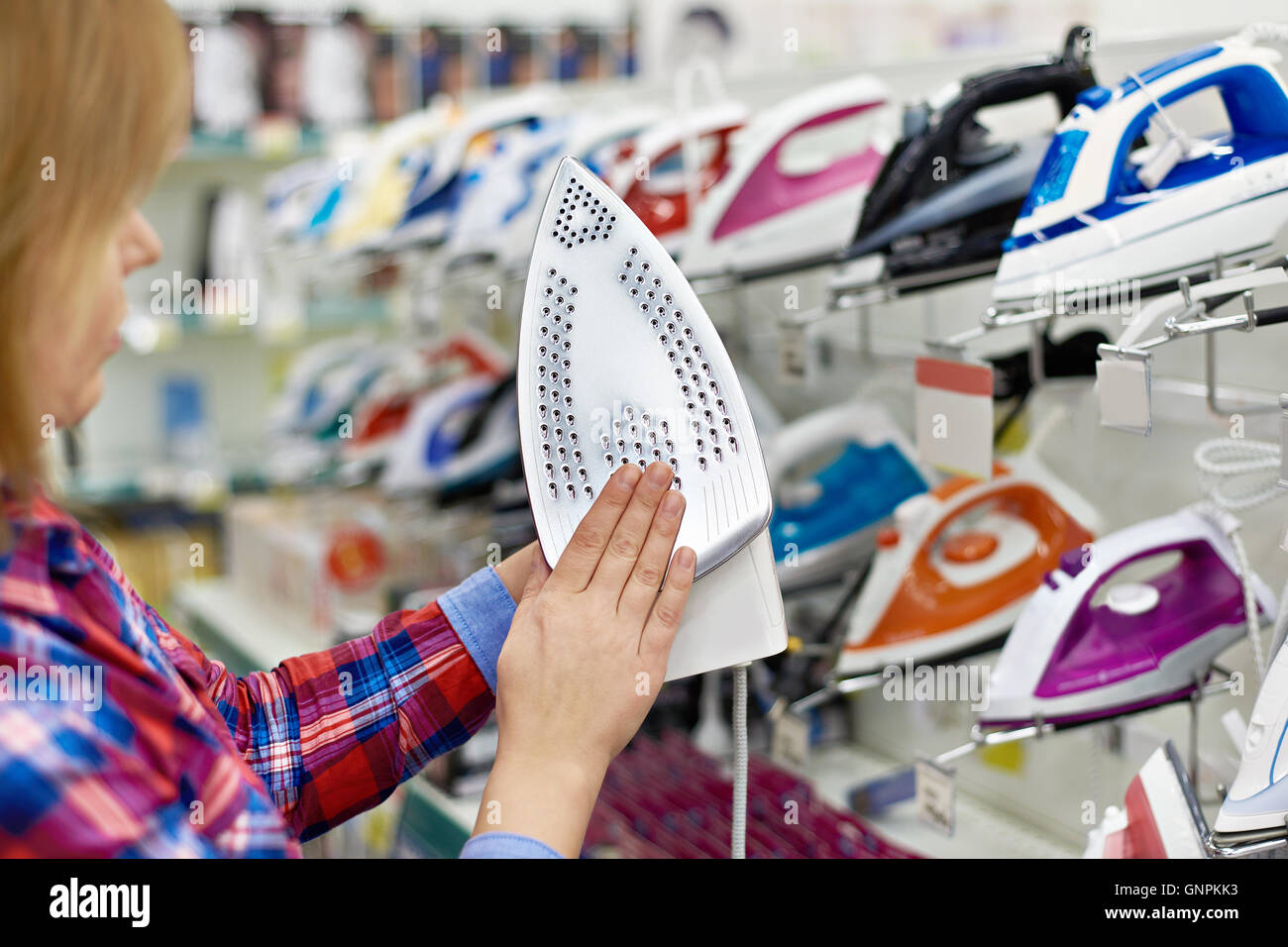 Donna shopping per il ferro nel negozio di close-up Foto Stock