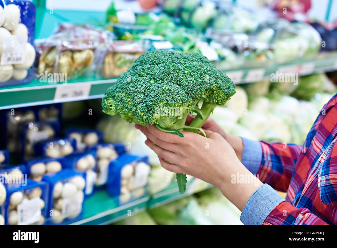 La donna acquista un broccoli in un negozio Foto Stock