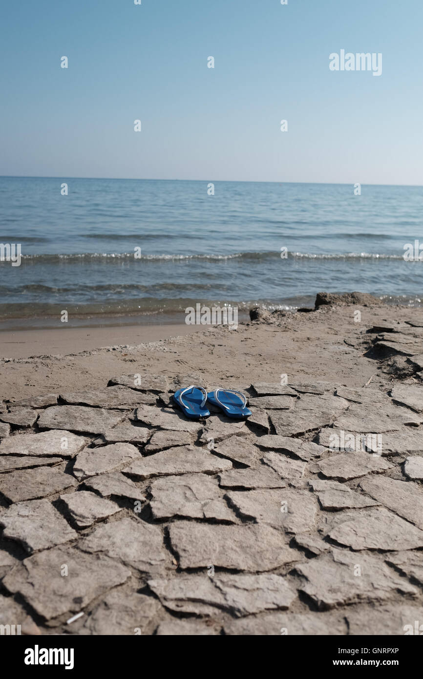 Una solitaria coppia di flip flop a sinistra sulla spiaggia Foto Stock