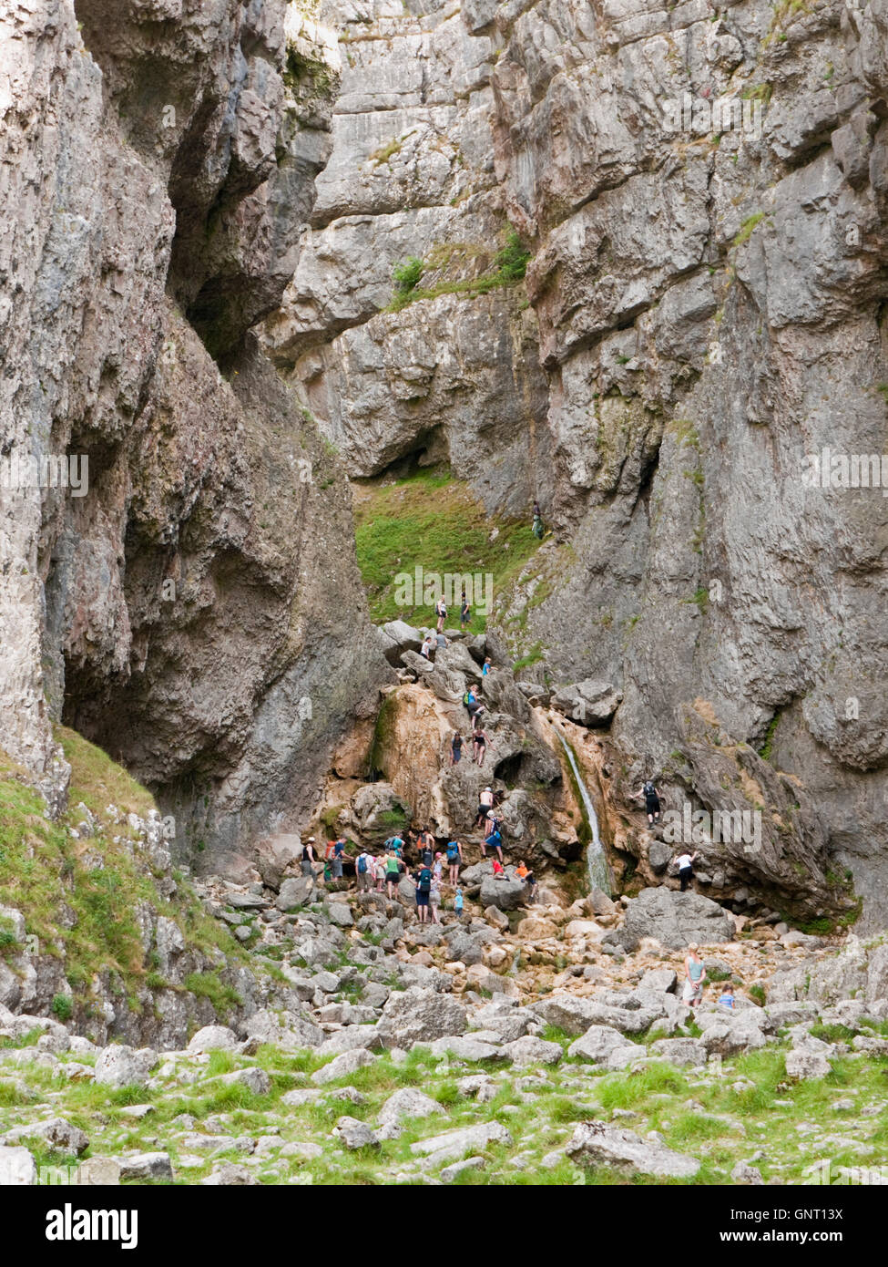 Walkers Arrampicata cascata a Gordale Scar una profonda gola vicino Malham, nel Yorkshire Dales National Park, Inghilterra Foto Stock