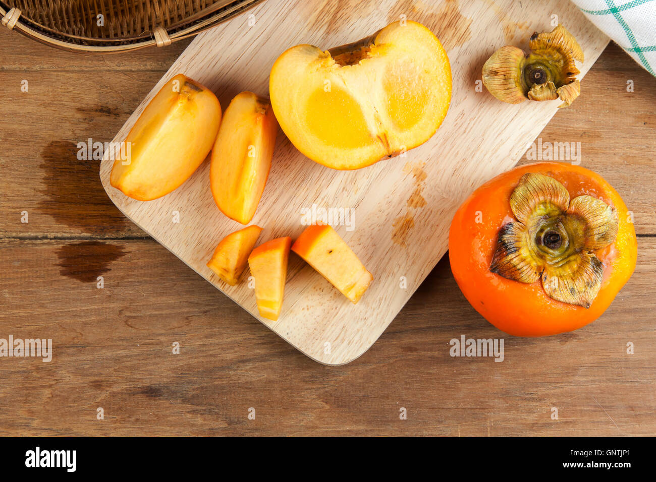 Persimmon colore giallo maturi frutti diviso sulla tavola di legno Foto Stock