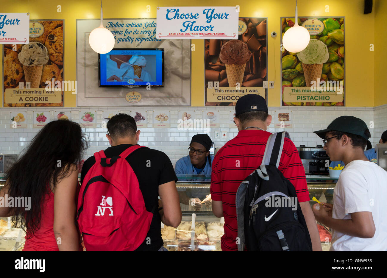 Vista interna di persone la scelta di gusti di gelato in una gelateria (coni di Coneys, New York). Foto Stock