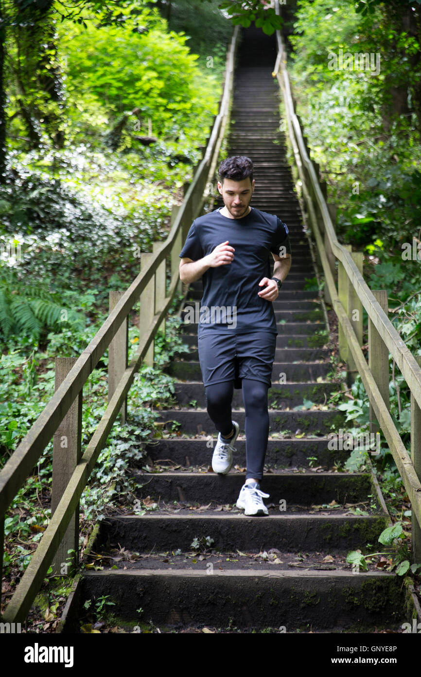 Uomo che corre sul sentiero forestale, di formazione e di esercizio. Fitness uno stile di vita sano concetto con atleta maschio. Foto Stock