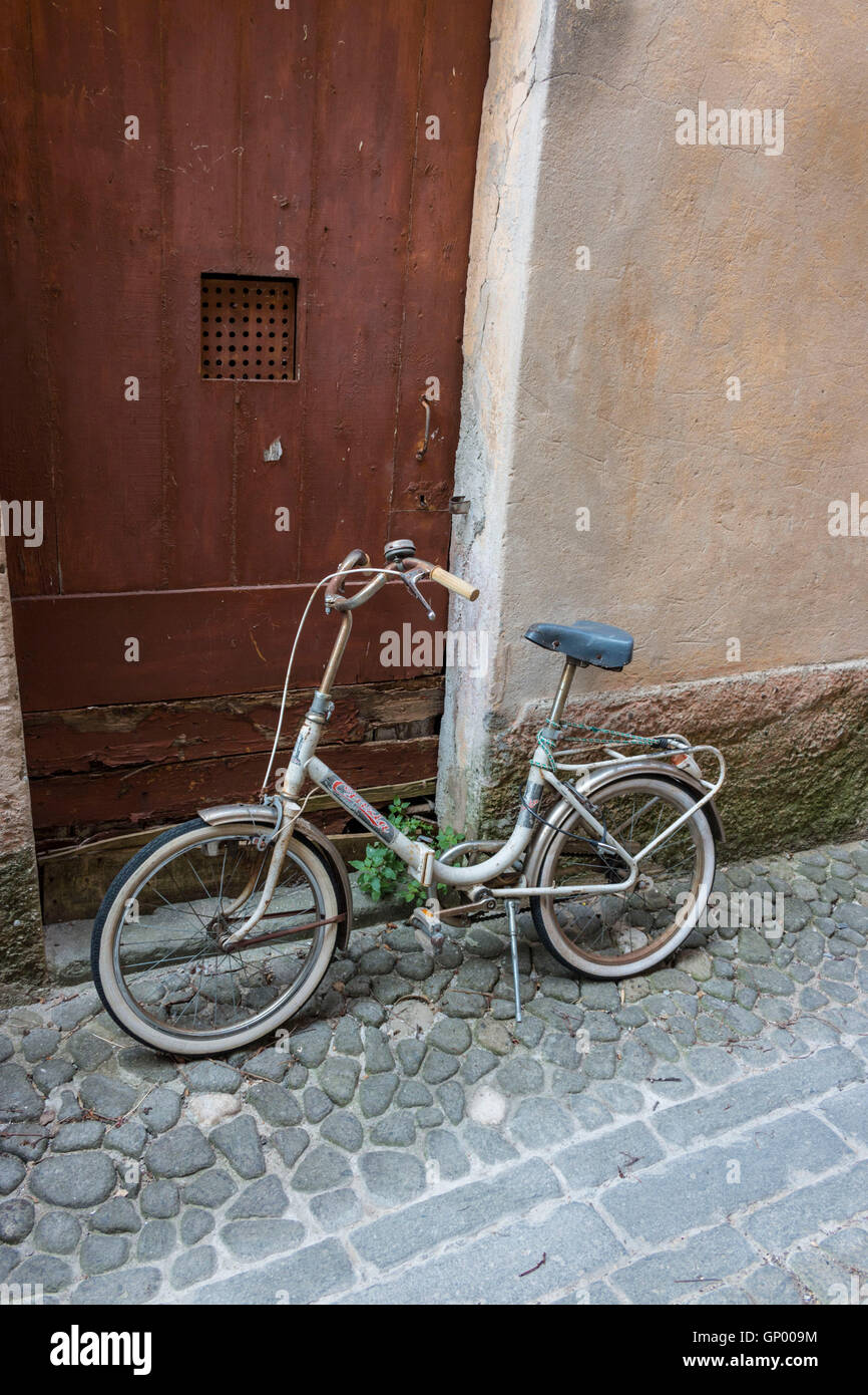 vecchio passo attraverso una bicicletta da donna in una strada acciottolata di una città francese Foto Stock