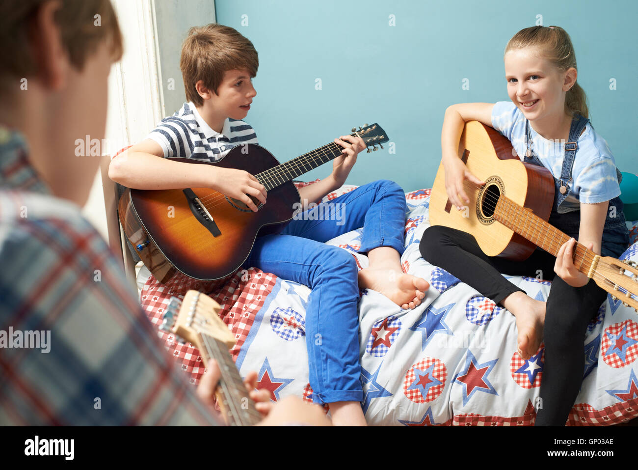 Bambini In camera da letto suonare la chitarra insieme Foto Stock