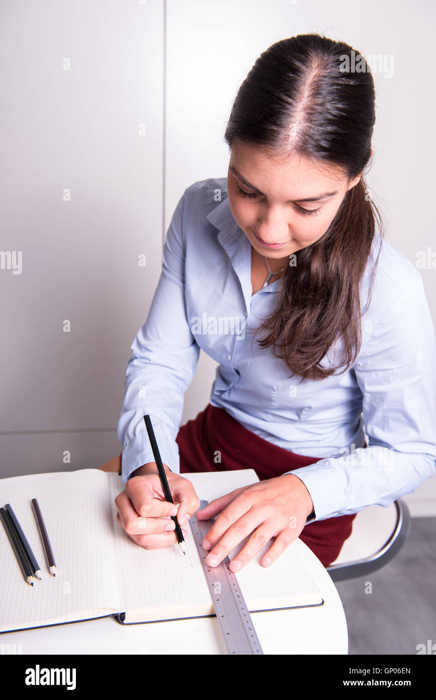 Giovane ingegnere femmina è il disegno in notebook aperto Foto Stock
