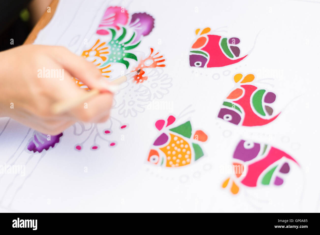 Procedimento Batik: donna artista dipinge su tessuto, Batik-making. Artista dipingere le creature sottomarine su un tessuto batik. F selettiva Foto Stock