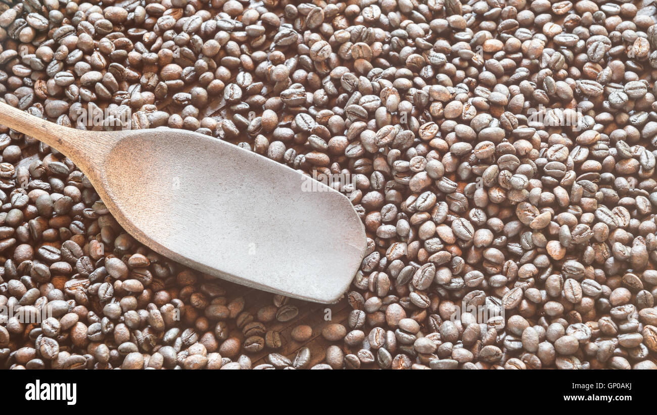 Caffè torrefatto in grani nel cestino con il mestolo di legno. copia di spazio. Foto Stock