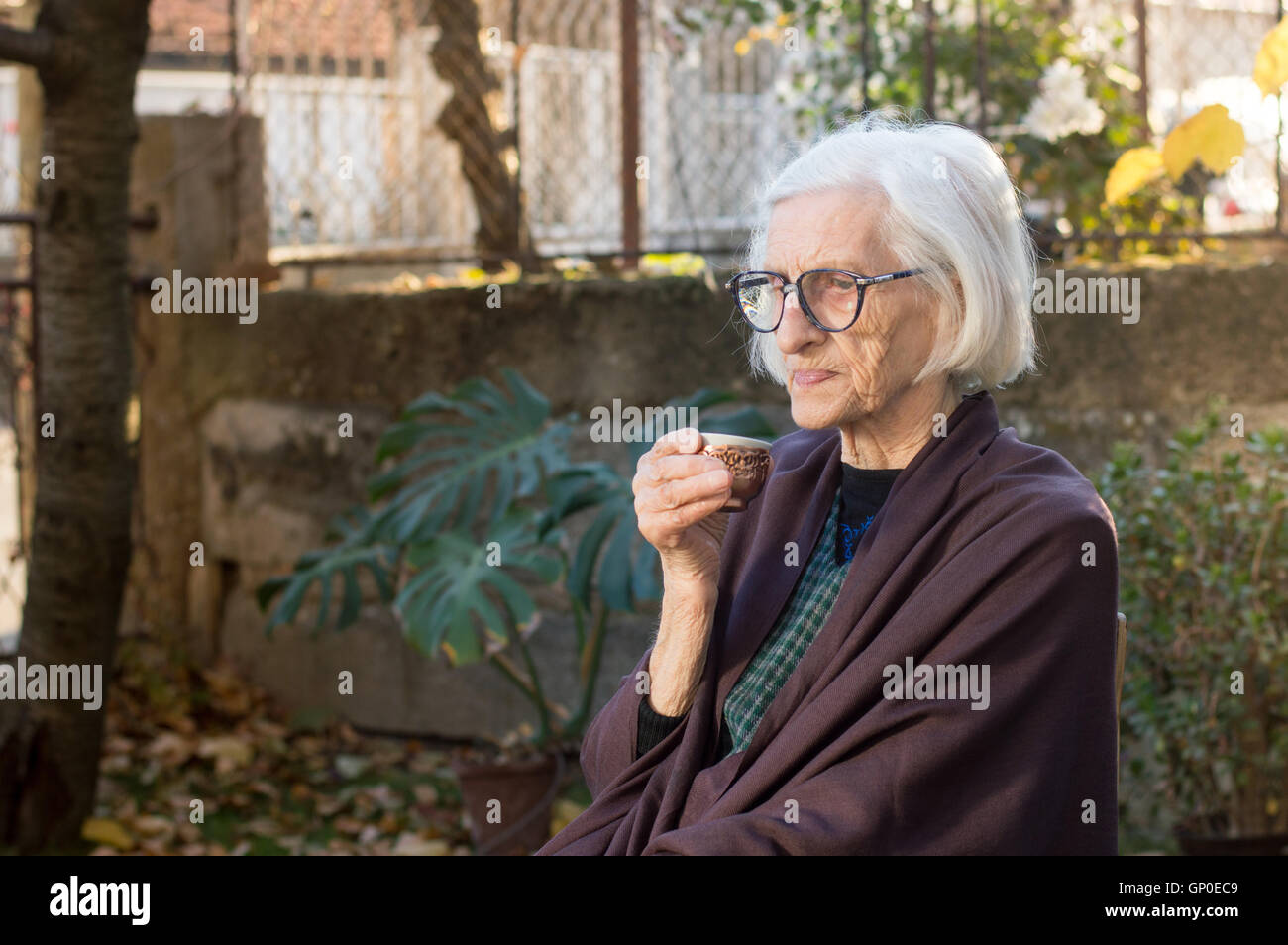 Senior donna con tazza di caffè all'aperto Foto Stock