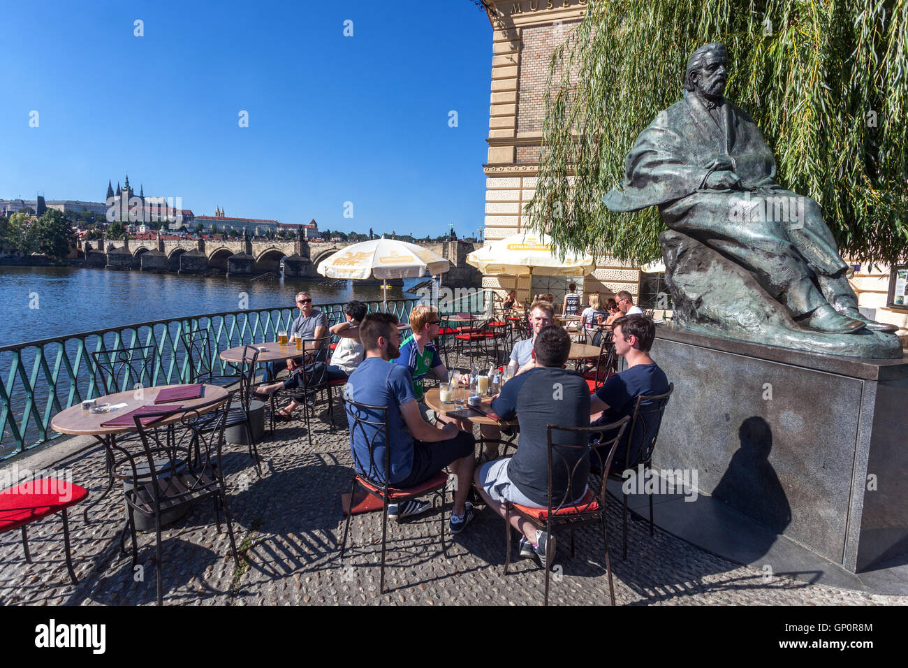 Turisti sotto la statua del compositore Bedrich Smetana con vista panoramica del Castello di Praga e del Ponte Carlo di Praga, ceco Foto Stock