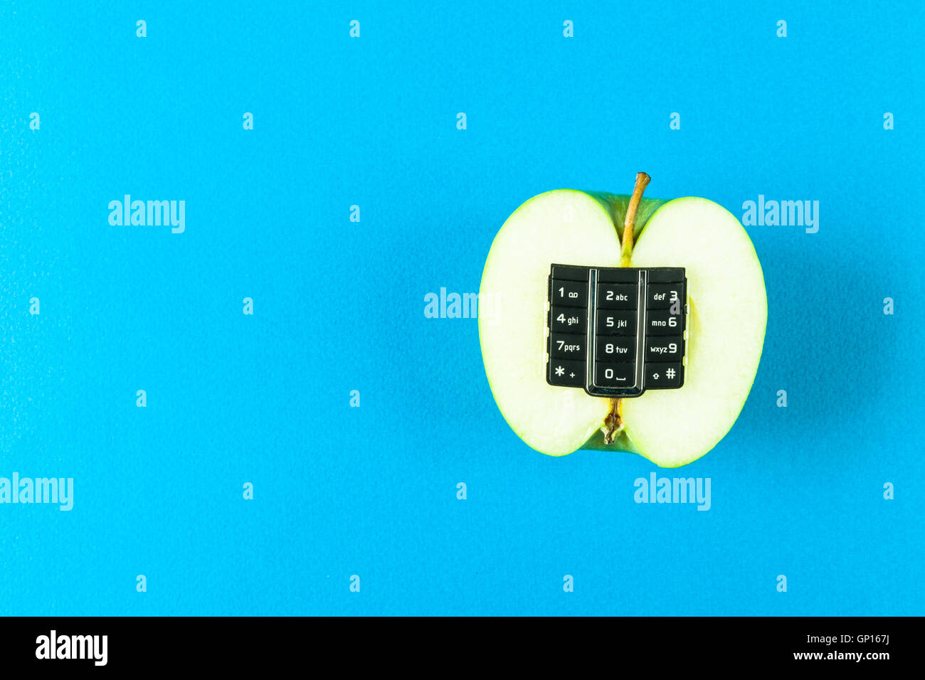 Apple con tastiera alfanumerica su sfondo blu Foto Stock